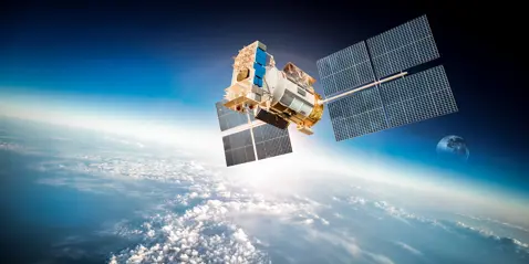 A satellite above the earth, clouds lightly covering the surface