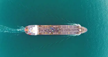 Luftfoto af tankskib, der sejler på turkisblåt vand