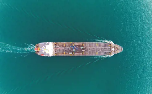 Luftfoto af tankskib, der sejler på turkisblåt vand