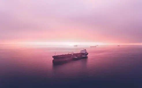 Vessel at sea with pink sky and water