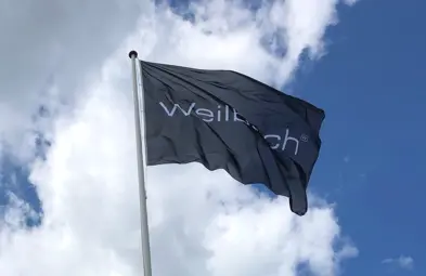 Mørkeblåt flagrende flag med Weilbach logo