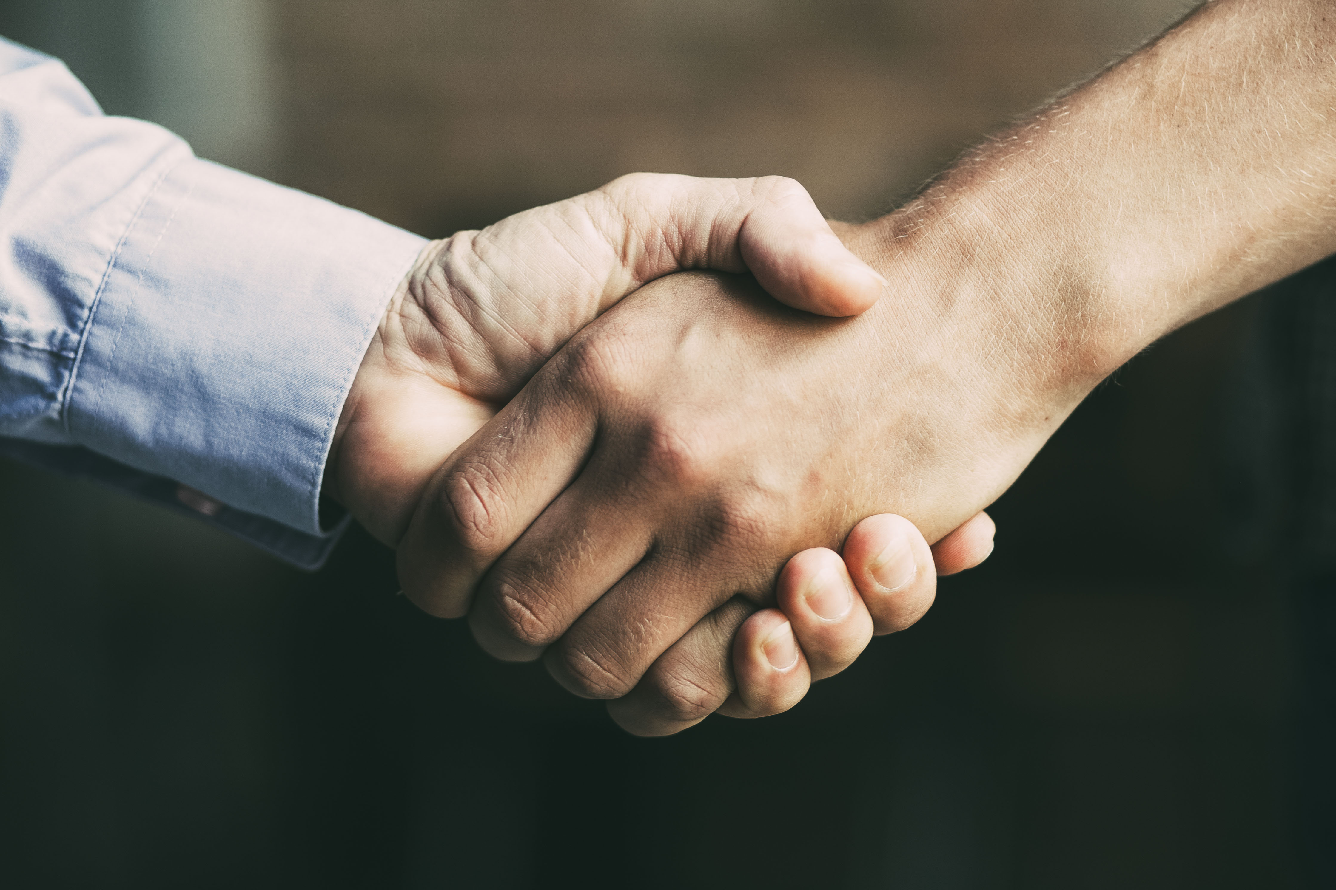 Nærbillede af to personer, der giver hånd