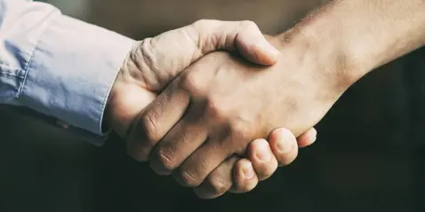 Nærbillede af to personer, der giver hånd