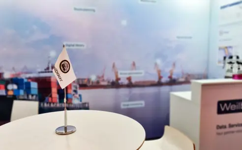 Table with Weilbach flag at Weilbach's stand at a shipping exhibition