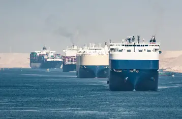 A convoy of container ships sailing through the Suez Canal