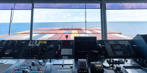 View from bridge out the window of the front of container ship 