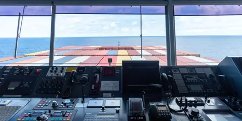 View from bridge out the window of the front of container ship