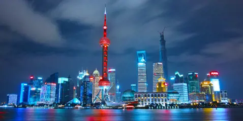 Shanghai skyline om natten: En fantastisk udsigt over Shanghais oplyste bybillede med høje bygninger og farverige lys.