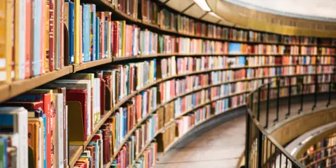 Curved bookshelves filled with colorful books in a library