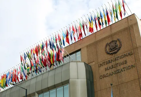 Foran IMO-hovedkvarterets bygning med flag fra alle lande