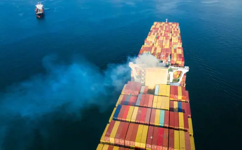 Large container vessel at sea emitting CO2