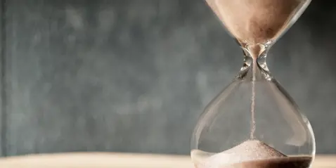Close-up of an hourglass with sand flowing